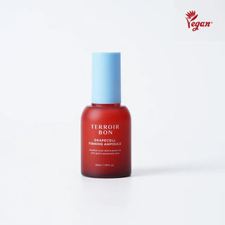 A bottle of Terroir Bon Grapecell Finishing Ampoule with a translucent red body and a light blue cap, set against a plain white background with a red Vegan logo in the top right corner.